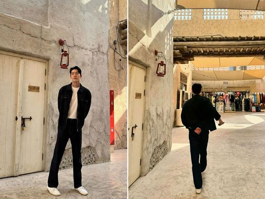 Kim Woo-bin poses against the backdrop of Al Seef's traditional architecture.