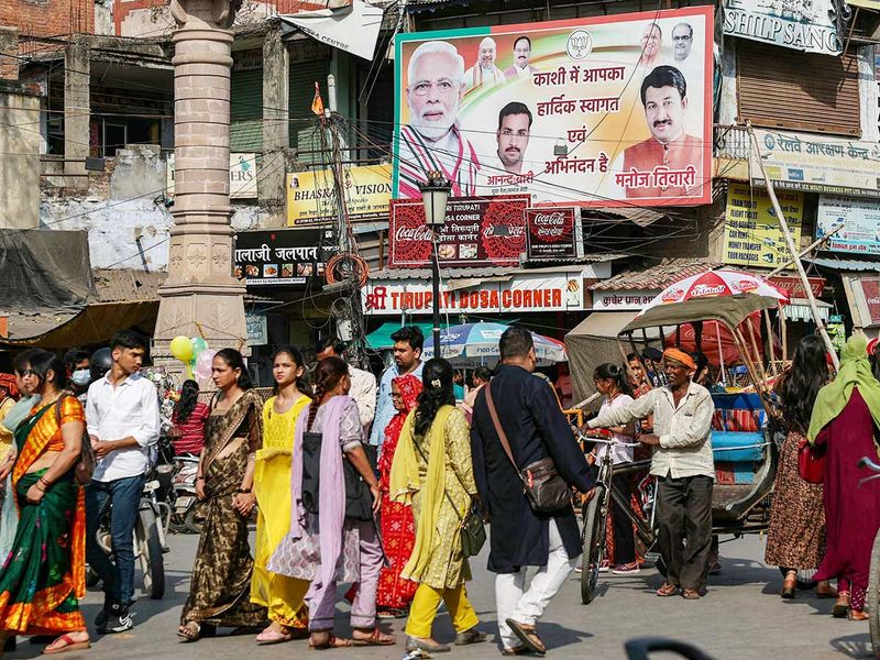 Traffic moves past a hoarding of the Bharatiya Janata Party (BJP) installed along the roadside in Varanasi on March 16, 2024.  