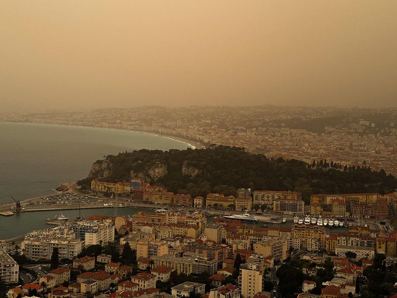 This photograph taken on March 30, 2024, shows thick sand dust blown in from the Sahara giving the sky a yellowish appearance above the French riviera city of Nice, southern France.  