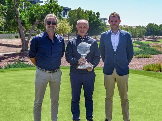 Barry Pavic, Amateur captain (R), Chris May, Chief Executive Officer of Dubai Golf (C) and Louis Gaughan, Professional captain (R), pose with the Dubai Golf Trophy