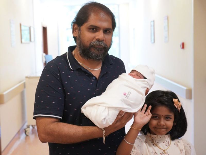 Indian dad Mohandas Balagurusamy holding their new baby-1712730934292