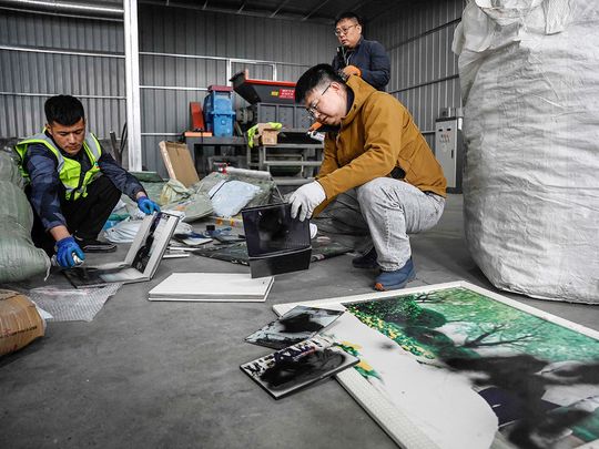 Liu Wei (R) and workers spraying paint on clients’ unwanted wedding photos at a warehouse in Langfang, in northern China's Hebei province.  