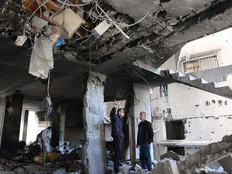 Palestinians inspect the damage to the home of the Tabatibi family