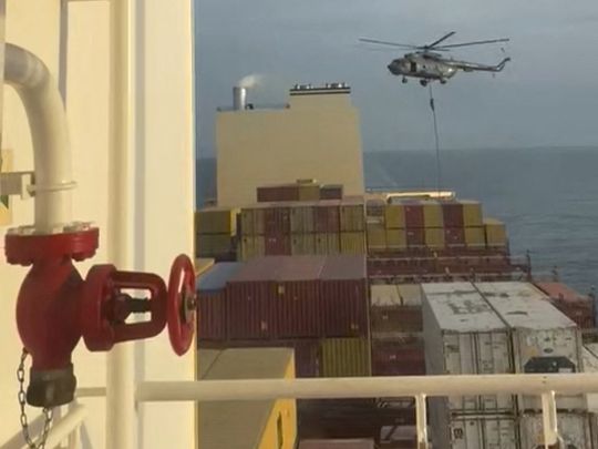 An official slides down a rope during a helicopter raid on MSC Aries ship at sea in this screen grab obtained from a social media video released on April 13, 2024.  