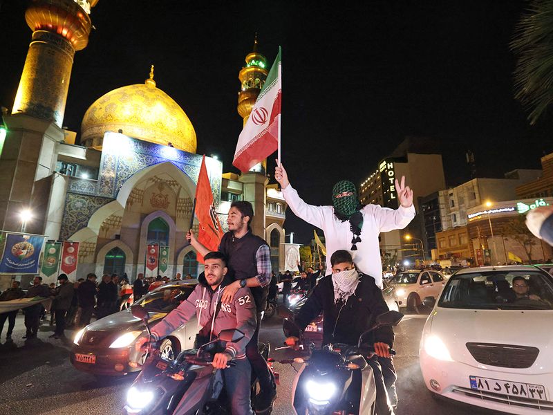 Demonstrators wave Iran and Palestinian flags as they gather at Palestine Square in Tehran on April 14, 2024, after Iran launched a drone and missile attack on Israel. 