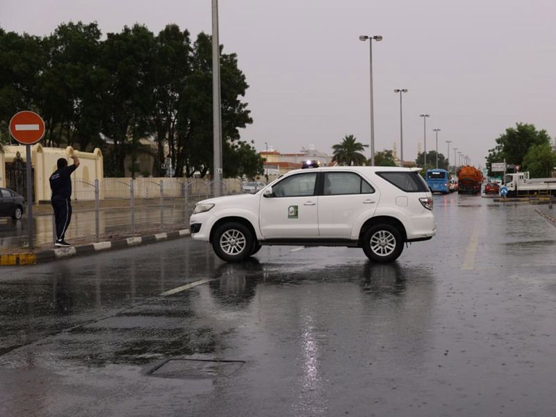 A Sharjah City Municipality patrol comes to the aid of residents in the rain 