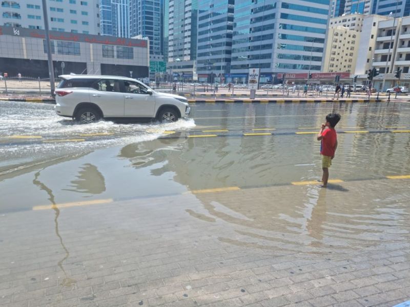 A vehicle drives ona flooded part of Sharjah's Al Estiqlal Street
