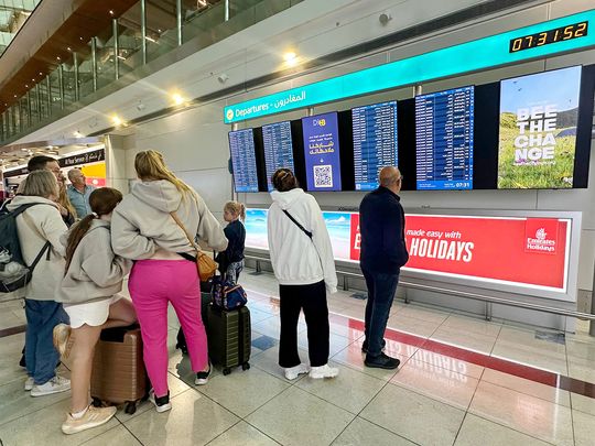 Passengers check flight information on screens at the Dubai International Airport in Dubai on April 17, 2024.  
