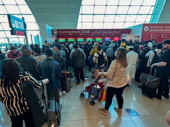 Passengers queue at a flight connection desk at the Dubai International Airport in Dubai. 
