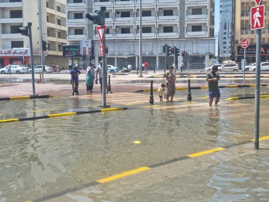 People wade through water-logged part of Al Estiqlal Street in Sharjah