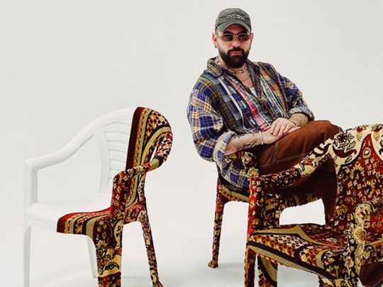 Ali Cha’aban sat on one of his Monobloc chairs covered with Persian rugs, 2023
