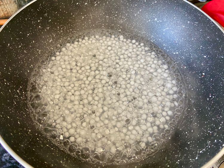 Add water to a pan, bring to a boil, add sago, cook for 10 to 15 minutes until translucent, then drain.