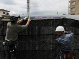 Workers erect a barrier to block the view of a popular Mount Fuji photo spot, near a convenience store in Fujikawaguchiko town, Yamanashi prefecture,