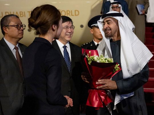 A member of the Chinese delegation presents a bouquet of flowers to President His Highness Sheikh Mohamed bin Zayed Al Nahyan, upon his arrival on Wednesday night at Beijing Capital International Airport commencing a state visit.