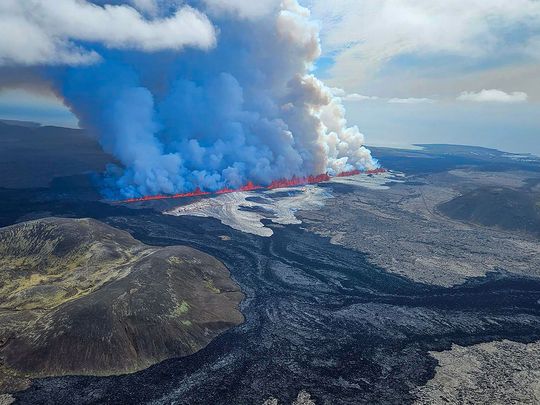 Billowing smoke and flowing lava pouring out of a new fissure, during a surveilance flight above a new volcanic eruption on the outskirts of the evacuated town of Grindavik, western Iceland.  