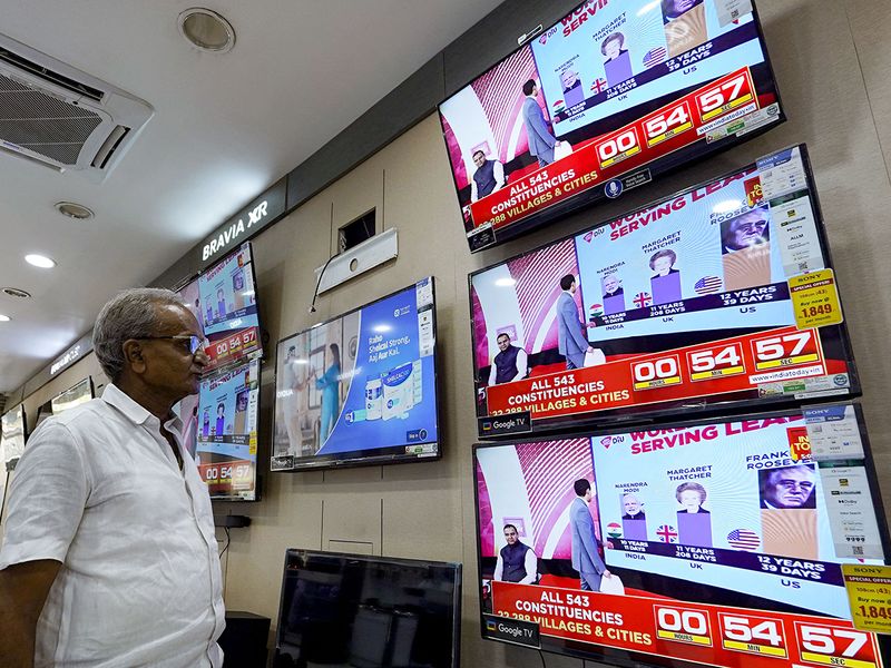 A man watching television waits for the release of exit polls 