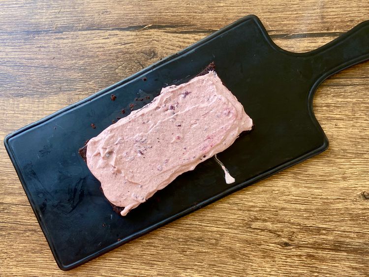 Place one half of the cake on a tray or a flat plate and apply the blueberry ice cream base using a spatula. 
