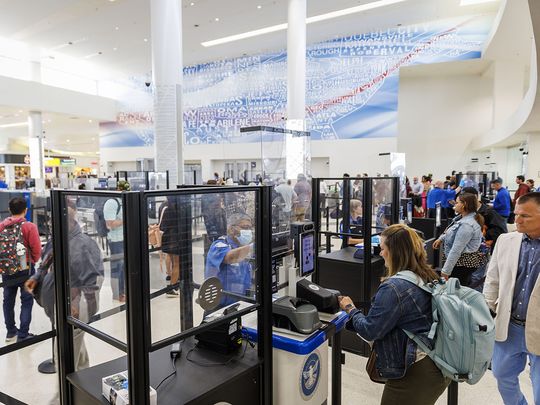 A traveller, bottom right, uses a Credential Authentication Technology (CAT-2) identity verification machine at a Transportation Security Administration (TSA) security checkpoint at Baltimore-Washington Airport (BWI) in Baltimore, Maryland, US, on Wednesday, April 26, 2023.