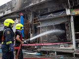 Firefighters try to extinguish a fire at a pet market next to Chatuchak market
