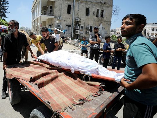 People carry the body of a Palestinian killed in Israeli strikes in Gaza City