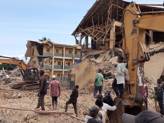 Rescue workers use heavy machinery at the site of a school that collapsed