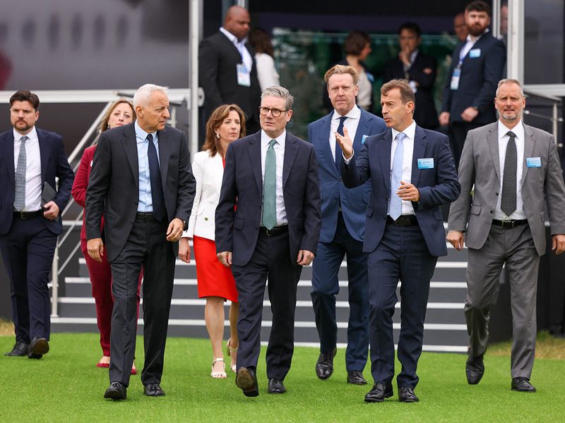 Tufan Erginbilgic, chief executive officer of Rolls-Royce Holdings Plc, left, Keir Starmer, UK prime minister, center, and Guillaume Faury, chief executive officer of Airbus SE, during the opening day of the Farnborough International Airshow in Farnborough, UK, on Monday, July 22, 2024. The aviation summit is typically a platform for planemakers to rack up multibillion-dollar deals. Photographer: Hollie Adams/Bloomberg