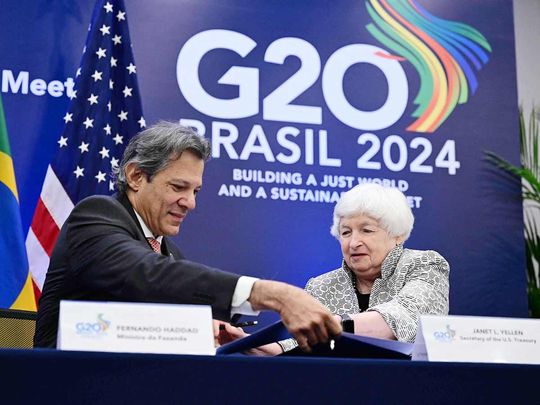 Brazil's Economy Minister Fernando Haddad (L) and US Treasury Secretary Janet Yellen sign an agreement 