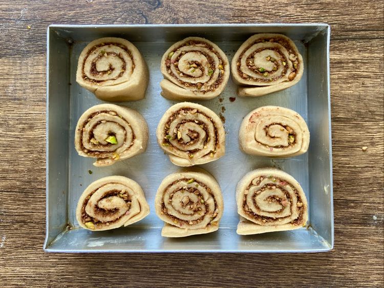  Slice the roll into 1.5-inch thick pieces. Grease a 9 x 7 inch baking tray and place the cut rolls in it.