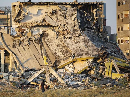 A man walks past the rubble of buildings destroyed 