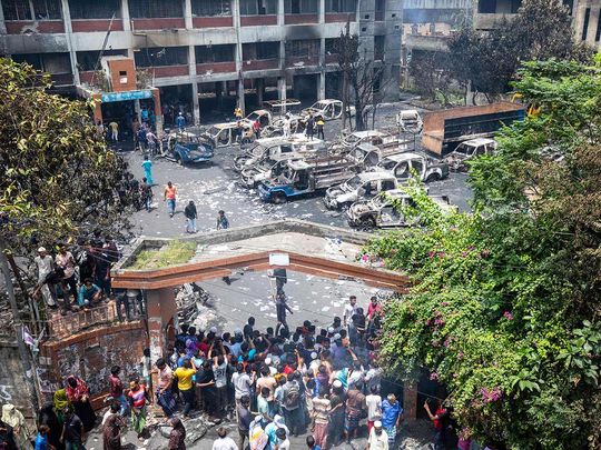 People gather to see the burnt Jatrabari police station