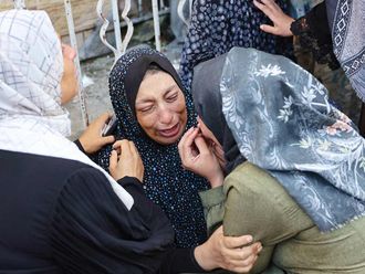 A woman reacts after identifying a member of her family 