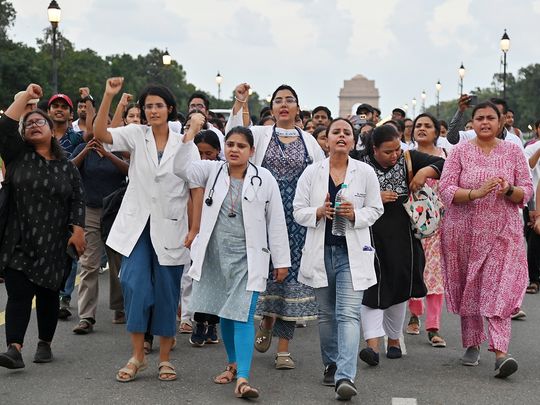 Doctors raise slogans during a protest against the alleged rape and murder 