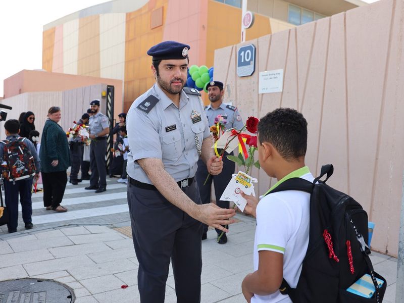 Abu Dhabi Police official greets a student on the first day of the new term on Monday