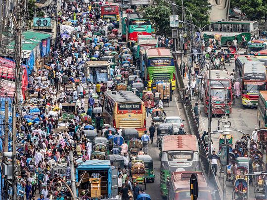 Commuters ride along a street in Old Dhaka