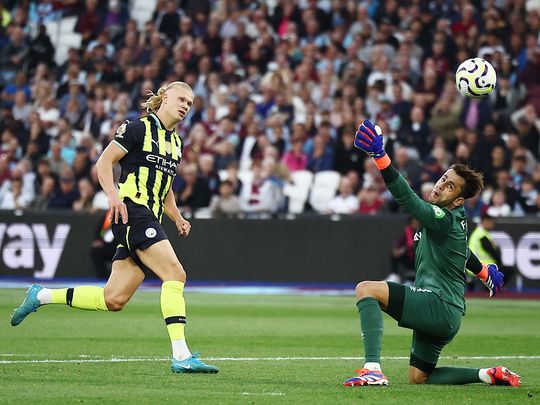 Manchester City's Erling Haaland (L) scores his third goal p