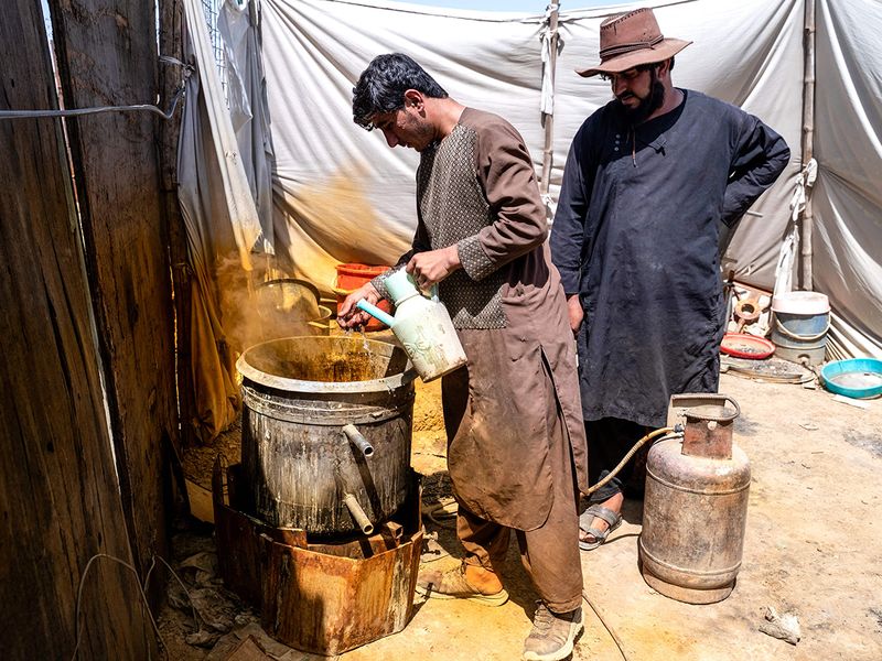 Afghan workers use acid to separate gold 