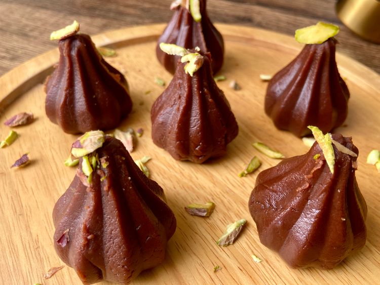 Garnish each modak with sliced pistachios and then serve.