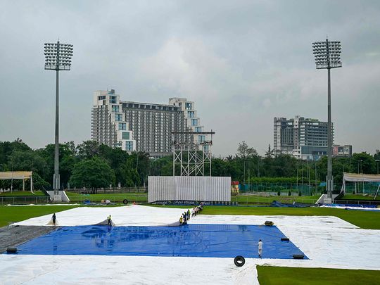 Groundsmen remove the field's cover