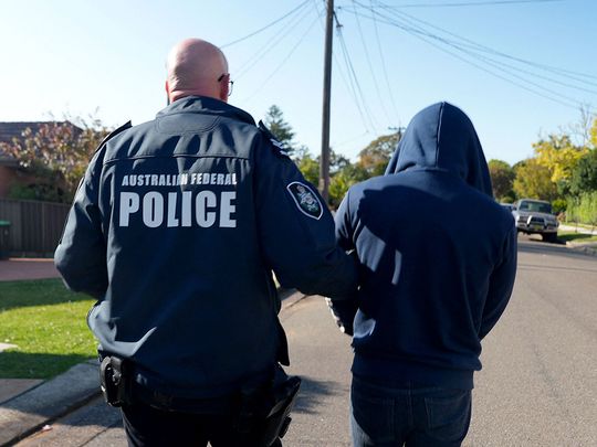 An Australian Federal Police officer arresting a suspect 