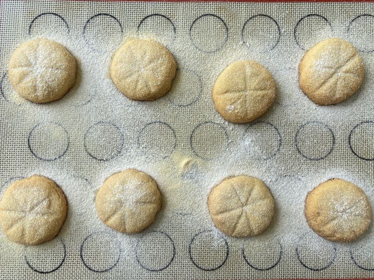 Once baked, remove the tray from the oven and immediately dust the cookies with icing sugar.