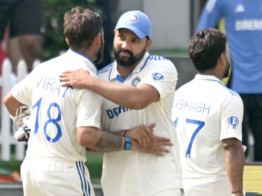 India's captain Rohit Sharma (C) embraces his teammate Virat Kohli (L)