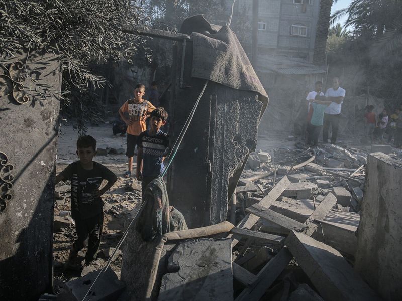 Palestinian children amongst the debris following an Israeli airstrike in Deir Al Balah,