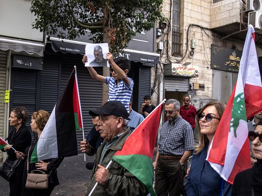 A young Palestinian boy holds up a portrait of slain Hamas leader Yahya Sinwar