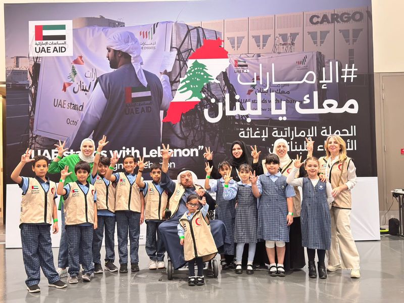 Elderly Emirati citizen Ali Salim Al Adeidi, who uses a wheelchair, poses for a picture with students at the  UAE Stands with Lebanon campaign in the Expo City Dubai on Sunday.