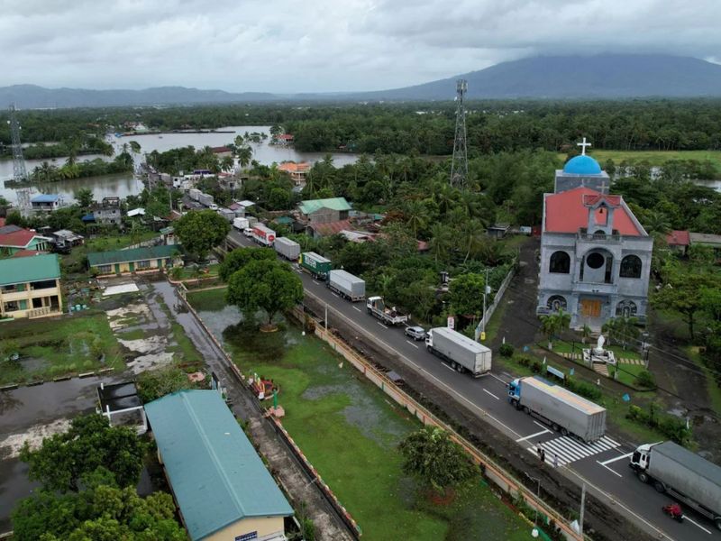 Cars and trucks are stranded along a flooded highway in Nabua town,