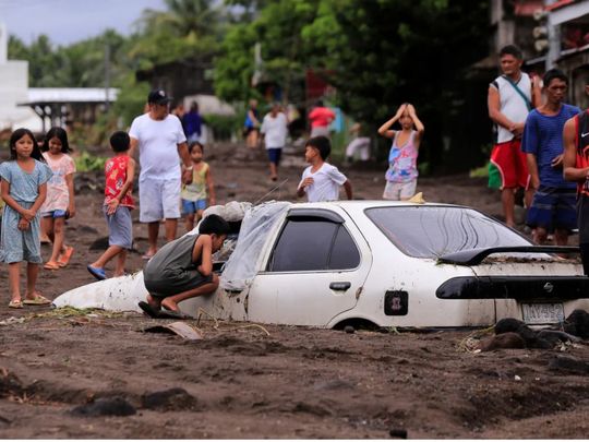 Residents look at a car Albay Mayon Trami Kristine