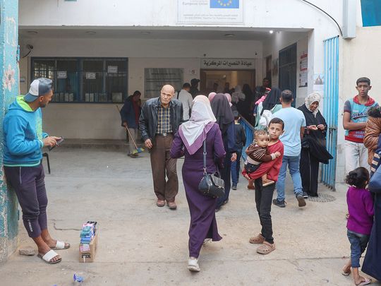 Palestinians walk into a healthcare clinic at the UNRWA 