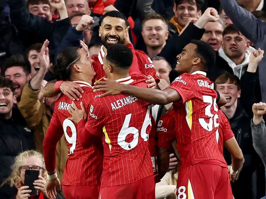 Liverpool's striker Mohamed Salah is mobbed by teammates 