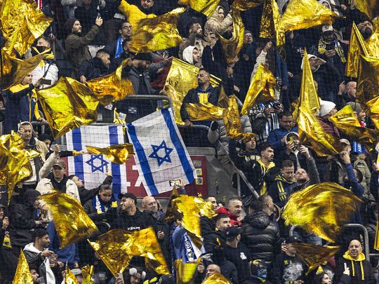 Maccabi supporters wave yellow flags 