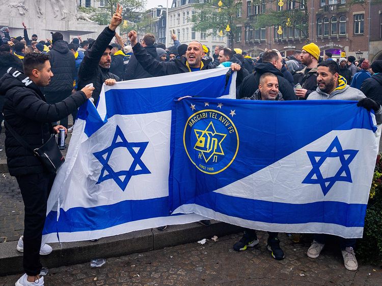 Supporters of Maccabi Tel Aviv hold flags at Dam square